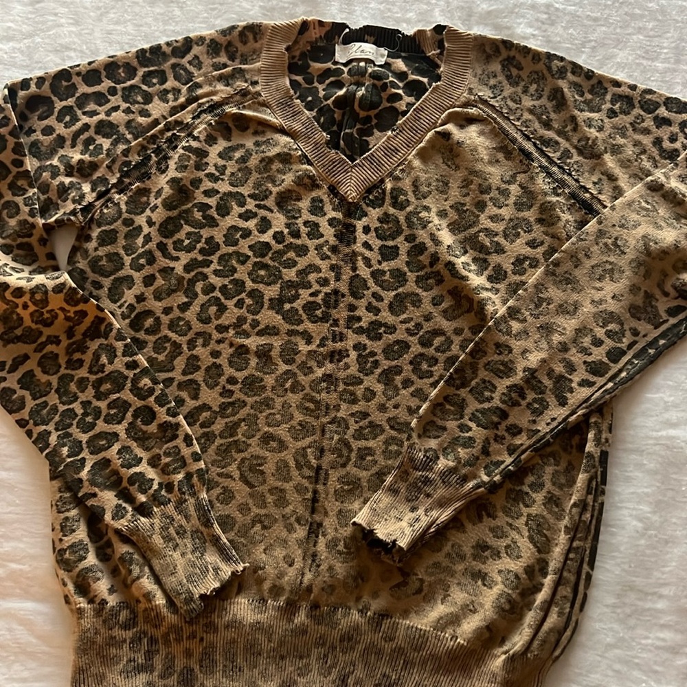 V neck leopard print sweater with distressing. Inside-out look.